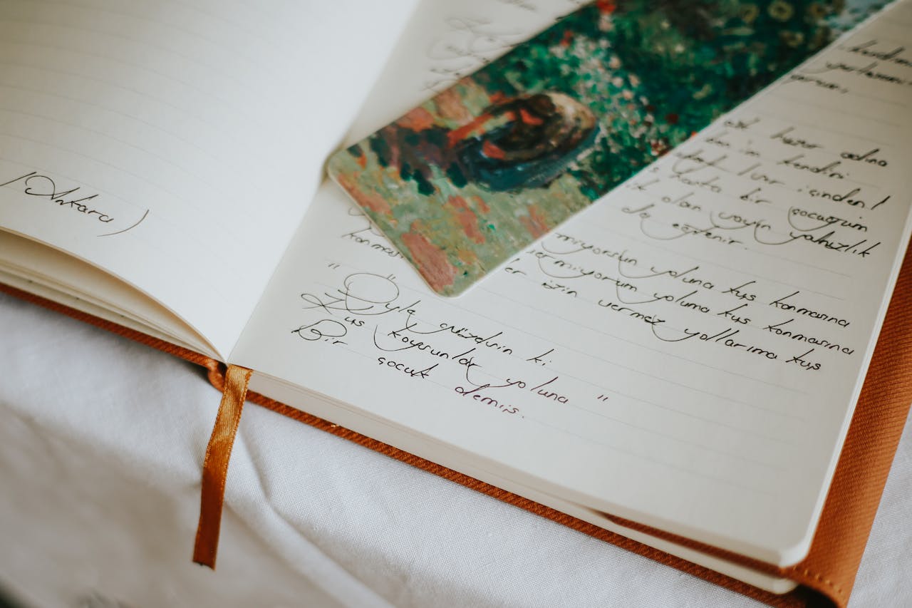 A close-up of an open journal with handwritten text and a colorful bookmark, evoking creativity.